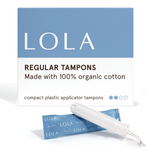 A box of Lola 20ct Regular Tampons stands behind a blue-wrapped tampon and a white BPA-free applicator, featuring clean blue and white packaging with a simple design.