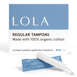 A box of Lola 20ct Regular Tampons stands behind a blue-wrapped tampon and a white BPA-free applicator, featuring clean blue and white packaging with a simple design.