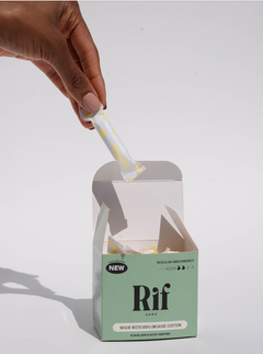 A hand holds a wrapped, plastic-free Rif Regular Absorbency Organic Non Applicator Tampon (18 ct) above an open green box labeled Rif Care, revealing more 100% organic cotton, biodegradable tampons inside against a white background.