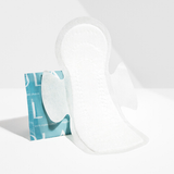 The Lola 20ct Ultra Thin Pads w/ Wings, Regular, stands upright beside its teal and white wrapper on a spotless white surface against a plain white background, highlighting its superior leak protection.