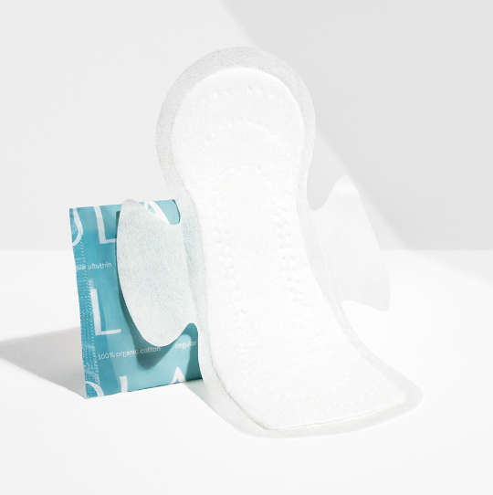 The Lola 20ct Ultra Thin Pads w/ Wings, Regular, stands upright beside its teal and white wrapper on a spotless white surface against a plain white background, highlighting its superior leak protection.