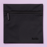 The Hello Wet Bag is a black, waterproof storage bag with a matte finish and “hello.” embossed in lowercase letters at the bottom right, shown against a light purple background.