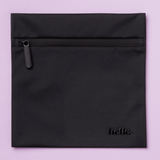 The Hello Wet Bag is a black, waterproof storage bag with a matte finish and “hello.” embossed in lowercase letters at the bottom right, shown against a light purple background.