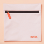 The Hello Wet Bag is a light pink waterproof storage bag with an orange zipper pull and "hello." printed in orange in the bottom right corner, shown on a matching light pink background.