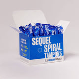 An open blue and white box labeled Sequel™ The Spiral™ Tampons reveals several individually wrapped, helical-grooved tampons. The box contains 32 regular tampons with modern, bold text designed for distraction-free periods.