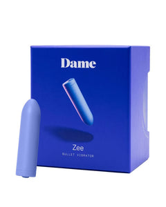 A compact, blue Zee Bullet Vibrator stands before its matching box, which is labeled with the product name and displays an image of the vibrator.