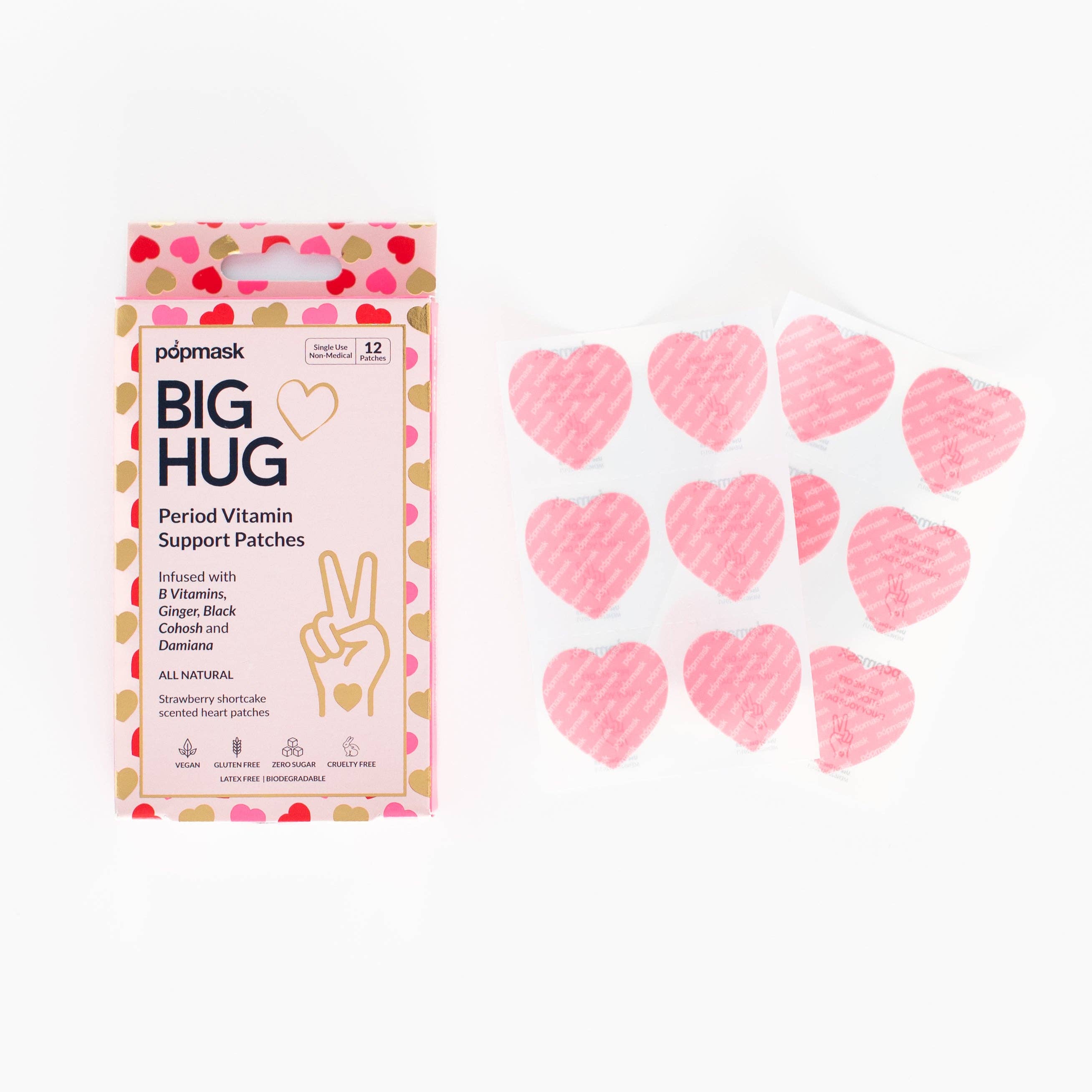 A box labeled Big Hug Period Support Vitamin Patches sits beside six pink heart-shaped patches in clear blister packaging. Decorated with pink and red hearts, the box offers PMS relief using convenient vitamin patches.