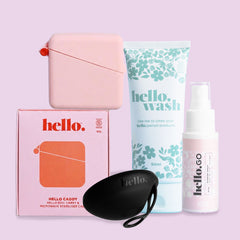 The Hello Disc Clean-on-the-go Bundle includes a black Hello Disc menstrual cup, pink storage case, floral “hello. wash,” pink “hello. GO” spray bottle, and “hello. caddy” box—all pictured on a light purple background.