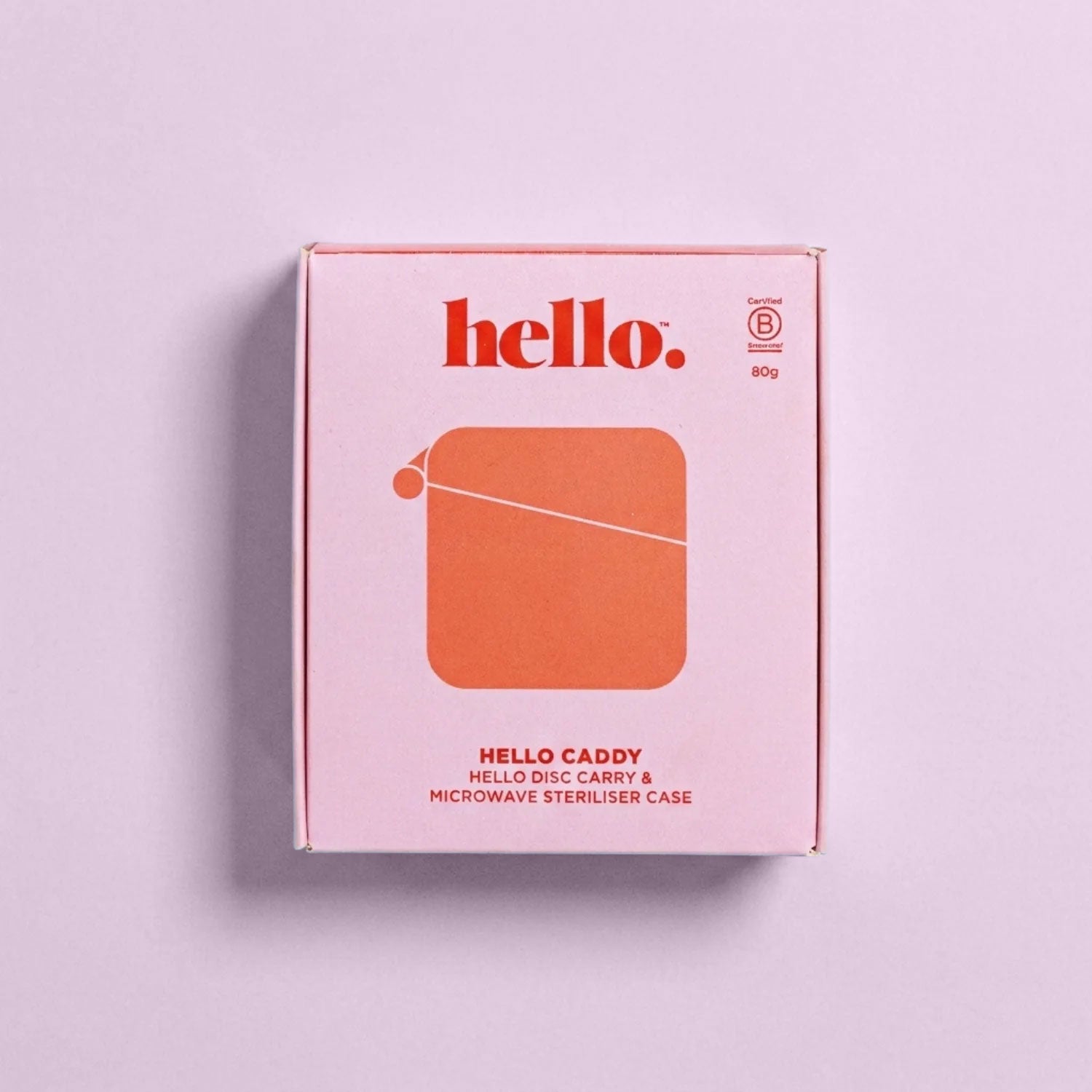A pink Hello Caddy box with red text reading "hello." and "HELLO CADDY HELLO DISC CARRY & MICROWAVE STERILISER CASE" sits on a light purple background. This case doubles as a period product cleaner and features a simple red graphic design.