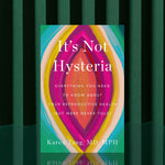 A vibrant copy of It's Not Hysteria: Everything You Need To Know About Reproductive Health stands upright on a green-striped background, its cover displaying bold abstract shapes in pink, orange, yellow, green, and blue.