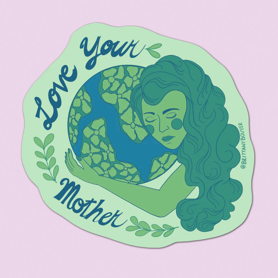 Love Your Mother Vinyl Sticker features a woman with long hair hugging the Earth, surrounded by leaves and “Love Your Mother” in flowing script on a pastel purple background. Perfect for celebrating women's empowerment.