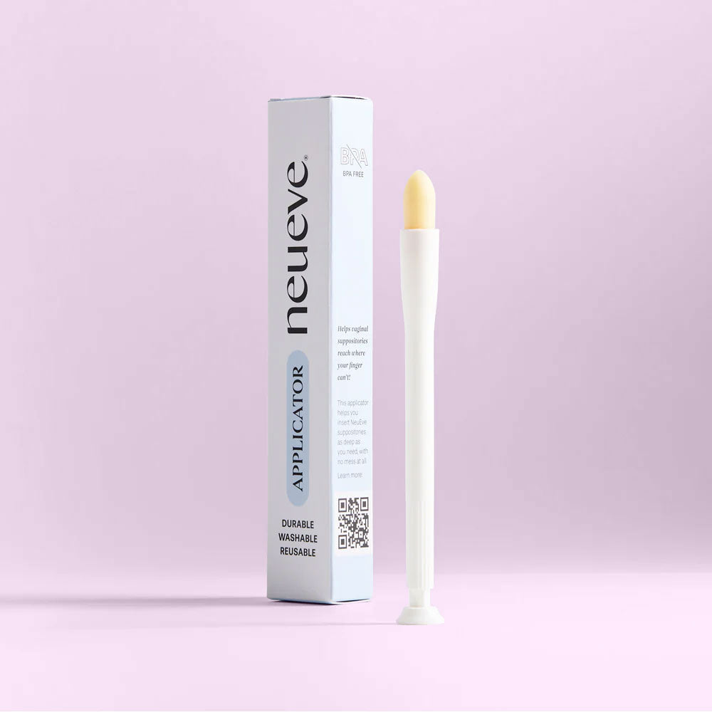 A white NeuEve Reusable Suppository Applicator with a rounded tip stands upright beside its tall packaging labeled "neueve" on a light pink background.