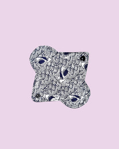 The Pennyroyal Reusable Period Pad - Single, made in Burnsville NC, features a black and white eye and scallop pattern and is shown on a light pink background.