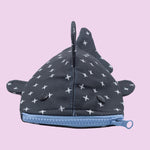 The Shark Week Pouch is a small, whale shark-inspired pouch with a blue zipper mouth, black button eyes, fins, and top fin. Its dark body features white cross patterns—ideal for storing period products or small items.