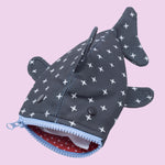 The Shark Week Pouch is a cute whale shark-shaped pouch with dark fabric, white X patterns, fins, a tail, and a blue mouth zipper. Its red polka dot lining makes it perfect for period products or as a coin purse.