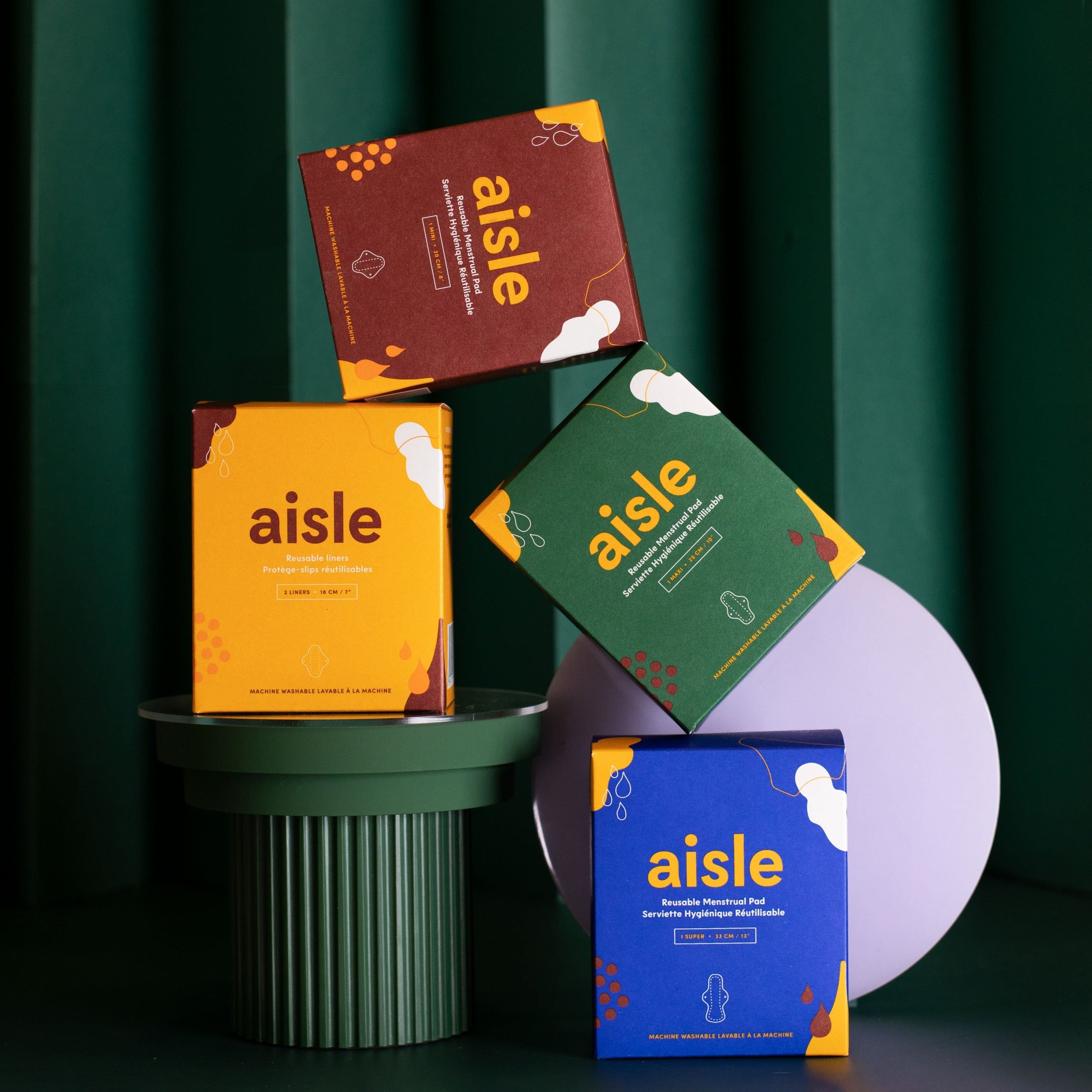 Aisle cloth pads in all size options in the colorful boxes stacked together