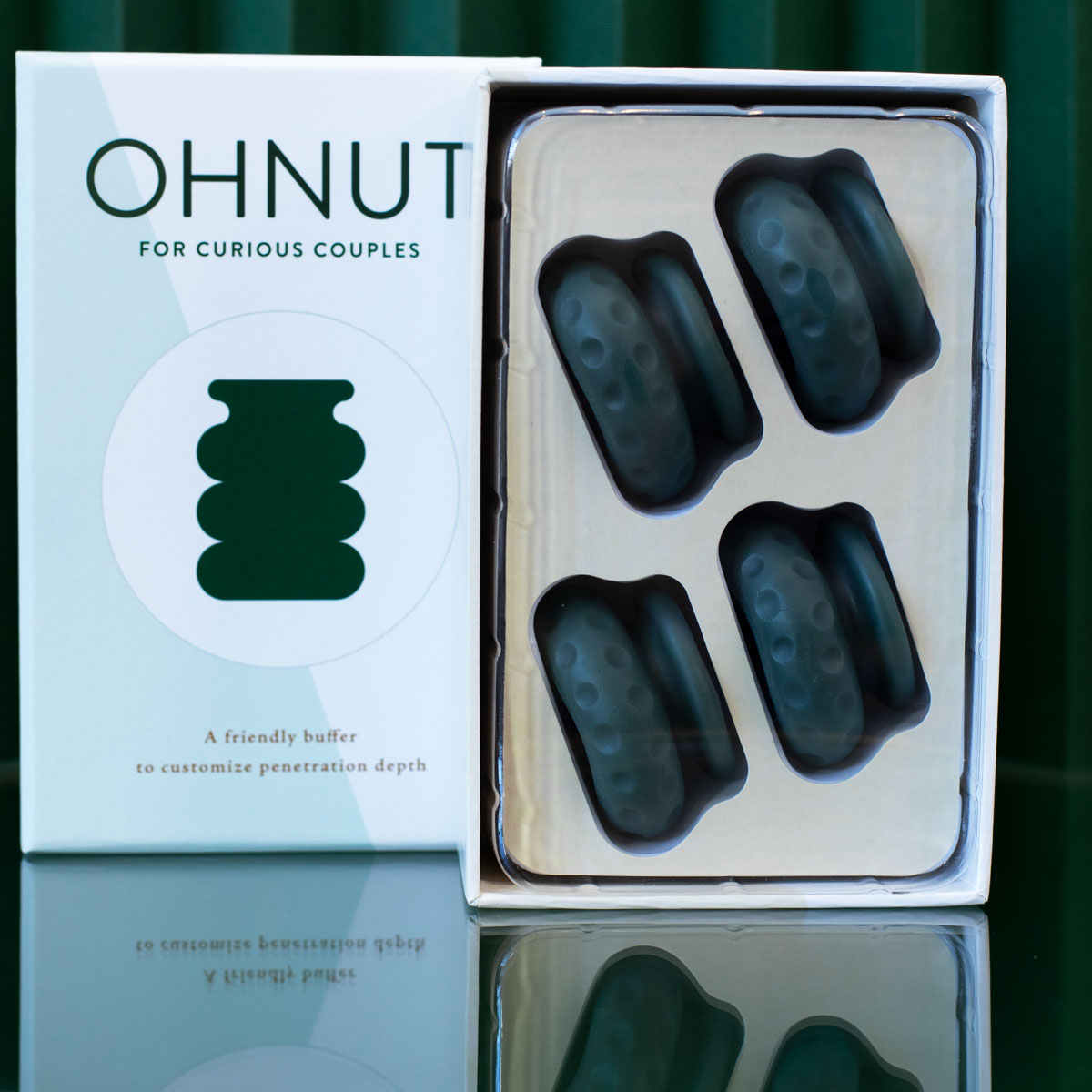 The Ohnut Buffer Rings - Set of 4 features stackable, dark teal, body-safe rings that let couples customize penetration depth for comfort. The box reads: "A friendly buffer to customize penetration depth.
